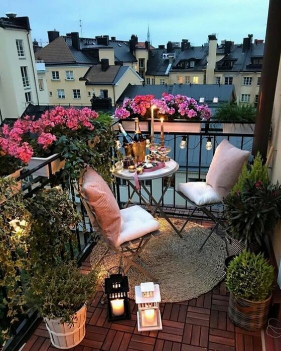 Decoración de terraza en colores claros con detalles de plantas alrededor