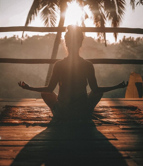 Chica practicando yoga en la playa