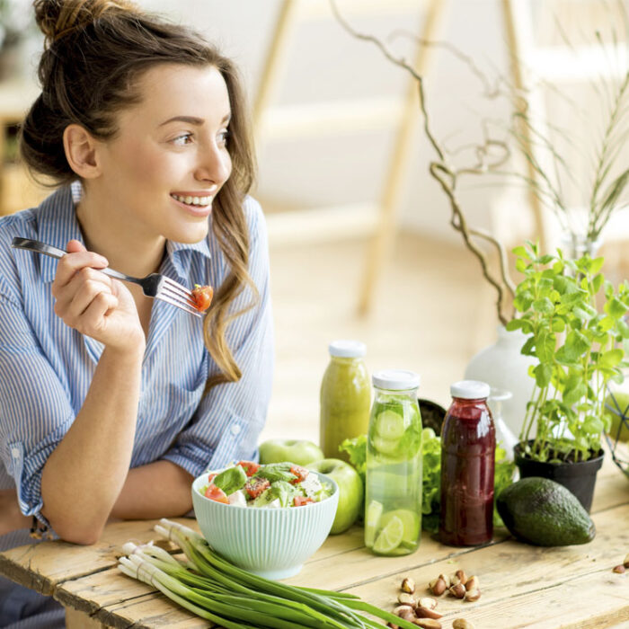 Chica sentada comiendo ensalada 