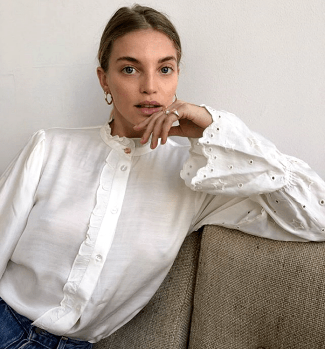 chica rubia usando una blusa blanca de botones con mangas abombadas y skinny jeans