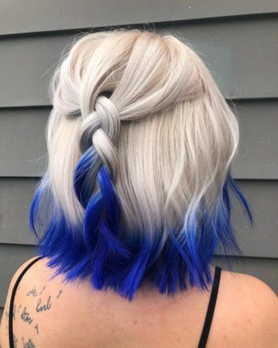 Chica con el cabello hasta la barbilla teñido de color platinado con las puntas en color azul 