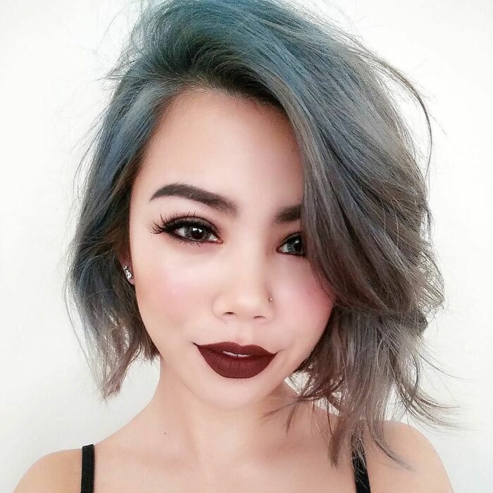 Chica con el cabello hasta la barbilla y teñido de color gris con azul 