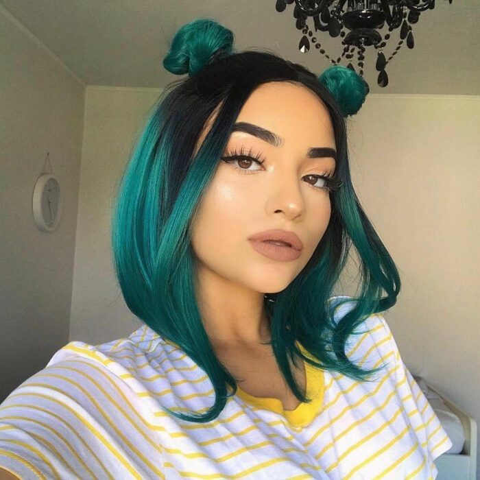 Chica con el cabello hasta los hombros y teñido en color verde con negro