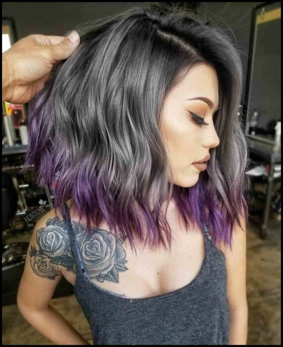 Chica con el cabello en corte bob y teñido en color gris con las puntas moradas 