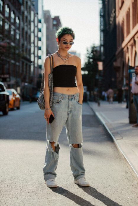 Chica usando unos pantalones baggy con un top de color negro