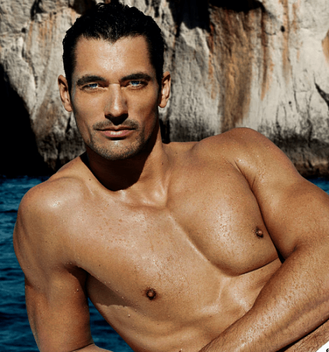 David Gandy, modelo de cabello oscuro con ojos azules, posando sin camisa en el mar