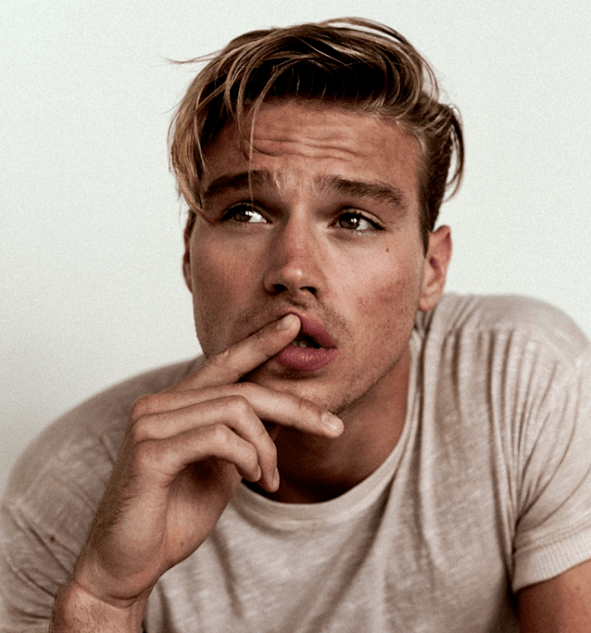 Matthew Noszka; chico rubio usando una camiseta beige de cuello redondo