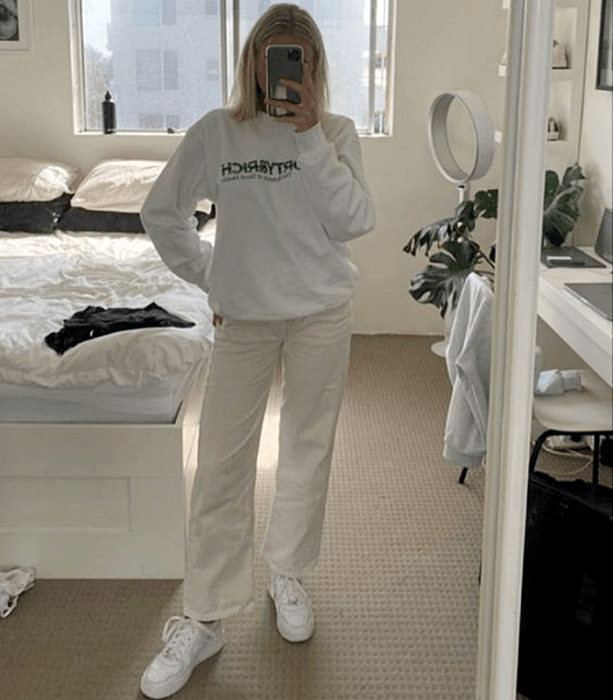 chica rubia usando una sudadera blanca, pants holgados blancos y tenis blancos deportivos