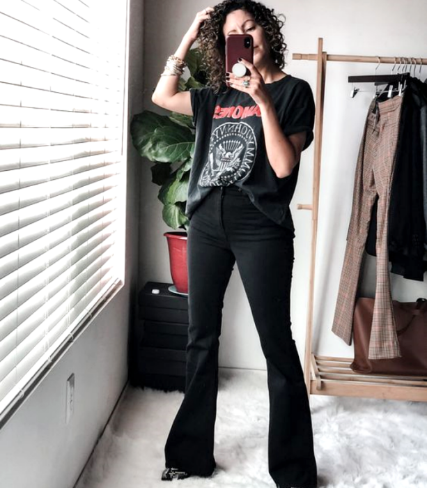 chinesisches Haarmädchen, das schwarzes Ramones-T-Shirt, schwarze ausgestellte Jeans, Pelzstiefeletten mit Tiermotiv trägt