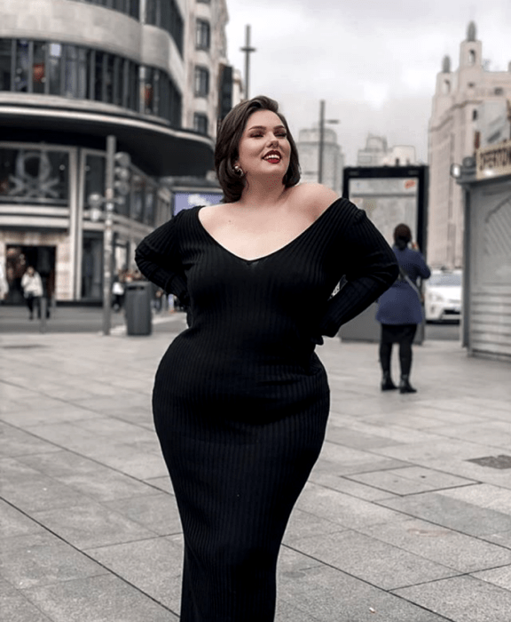 chica curvy usando un vestido tejido negro de cuello en V y manga larga, ajustado