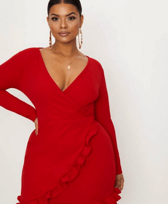 chica morena curvy usando un vestido rojo de manga larga, cuello en V, ajustado a la cintura