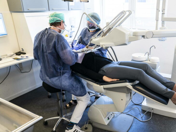 Dentistas atendiendo a paciente en su consultorio