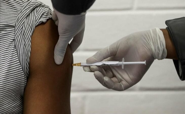 Médico aplicando una inyección el brazo de una persona