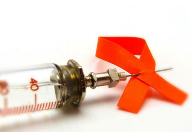 Gerinja con un lazo rojo, indicando la lucha contra el VIH