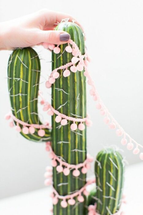 Cactus de adorno decorado con una guirnalda rosa pastel con bolitas