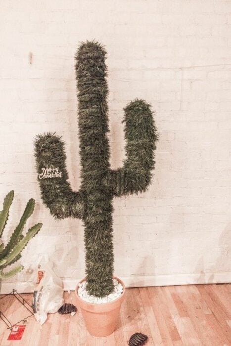 Árbol de navidad en forma de cactus sin decoración y con pared blanca de fondo