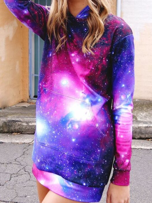 Chica rubia con cabello suelto ondulado con sudadera larga con estampado de galaxia 