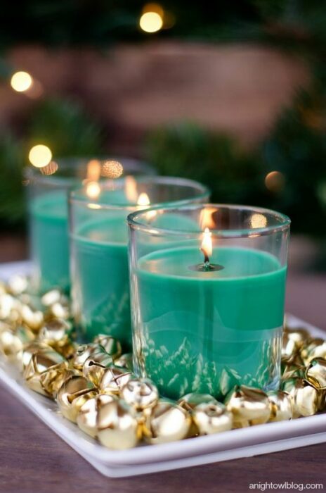 Velas color azul Tiffany en una plato blanco con cascabeles dorados