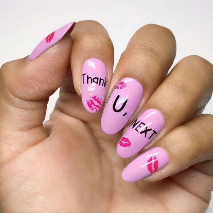 Manos con uñas largas en forma de almendra pintadas con esmalte color rosa bebé, inspiradas en thak u next de Ariana Grande, con marcas de besos