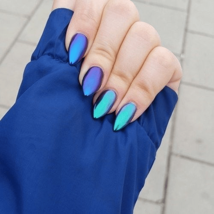 Chica con las uñas en un diseño metálico de color azul tornasol 