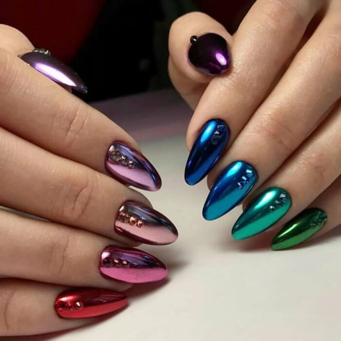 Chica con las uñas en un diseño metálico de diferentes colores 