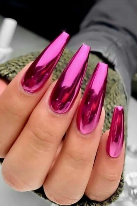 Chica con las uñas en un diseño metálico de color rosa fuccia 