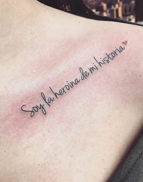 Chica con un tatuaje en el hombro en forma de frase en español