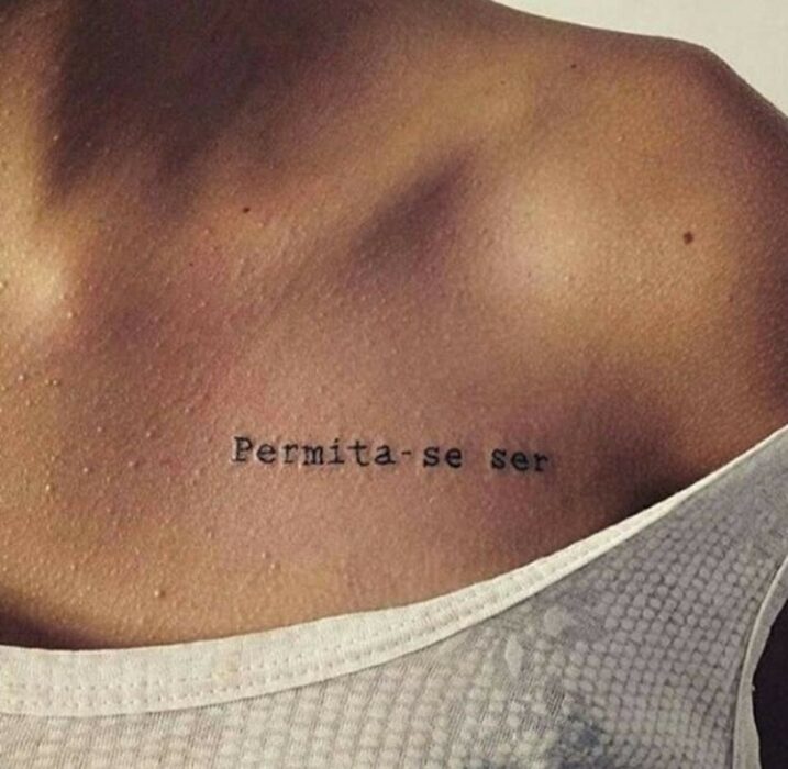 Chica con un tatuaje en la clavícula en forma de frase en español