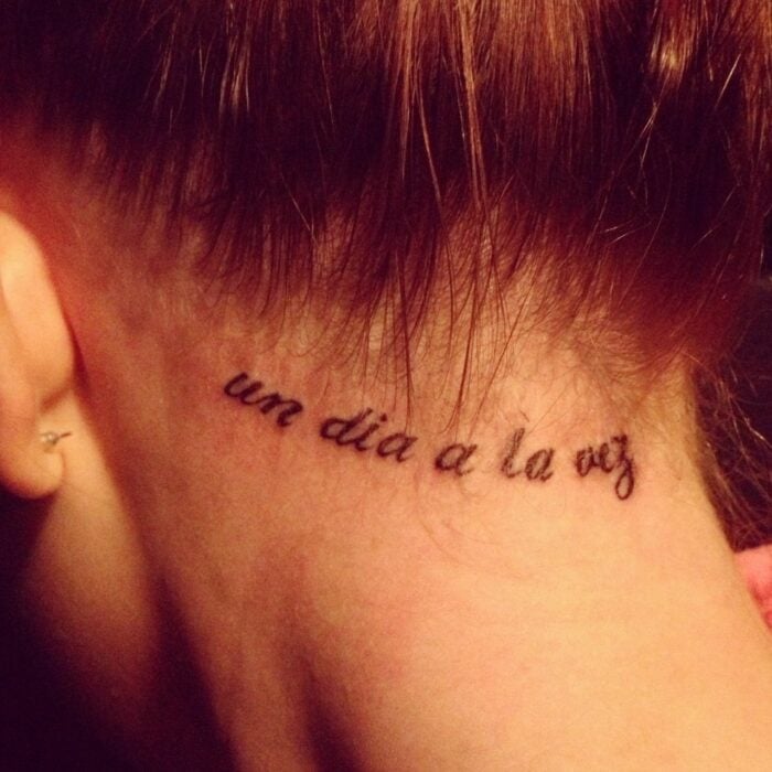Mädchen mit einem Tattoo am Hals die Legende: "einen Tag nach dem anderen"