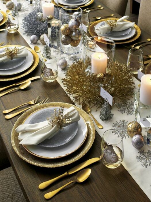 Mesa decorada con cubiertos en tonos blancos y dorados; Ideas para decorar la mesa en Navidad