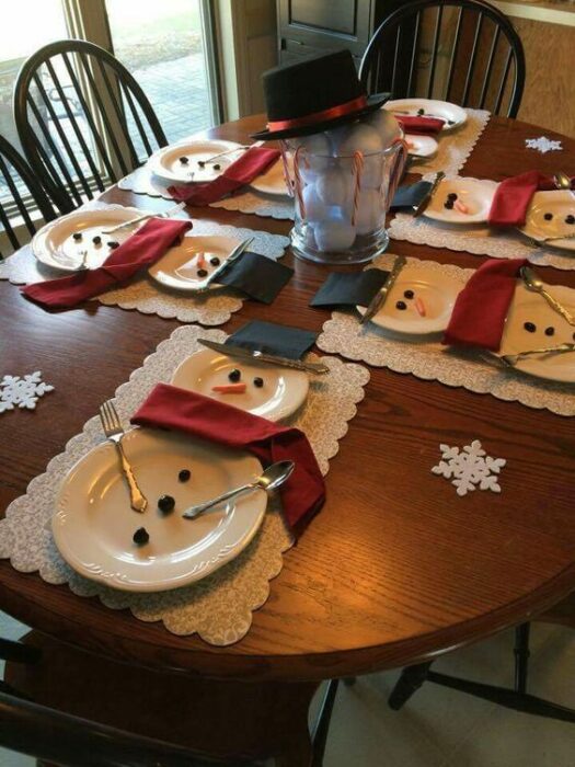 Cubiertos blancos acomodados en forma de muñecos de nieve; Ideas para decorar la mesa en Navidad