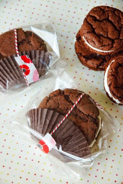 Galletas de chocolate envueltas en bolsitas de celofán transparentes con un lazito rojo con blanco 