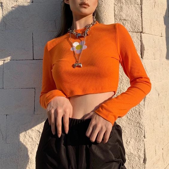 Chica llevando un top naranja con estampado de margaritaIdeas para usar color naranja en tu outfit