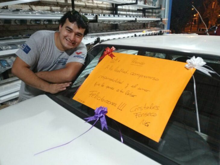 Hombre sonriendo junto a su automovil