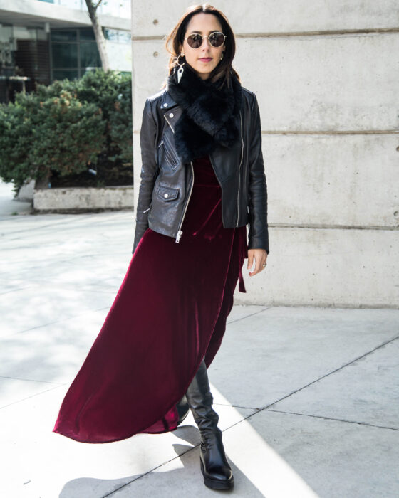 Chica usando un vestido de color guinda con una chaqueta de cuero, bufandas y botines 