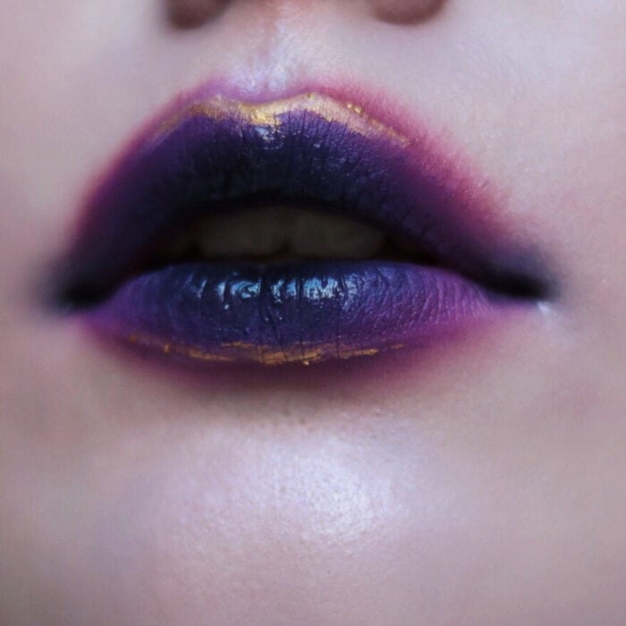 Künstlerisches Lippen Make-up von Maskenbildnerin Tatiana Rose;  Mund mit lila Lippenstift mit Lutscher-Effekt verschwommen, Gold umrandet
