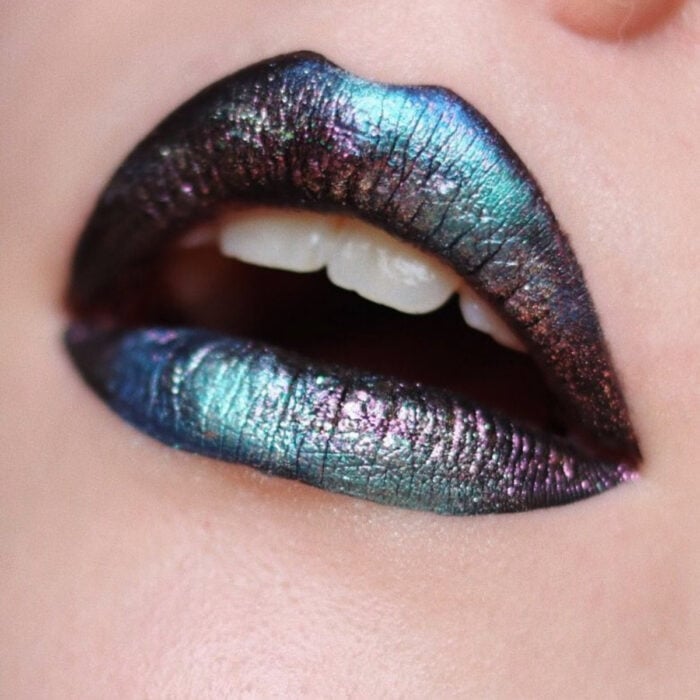 Maquillaje artístico de labios por maquilladora Tatiana Rose; boca con labial efecto oil slick o petróleo, color negro, azul y morado con brillos