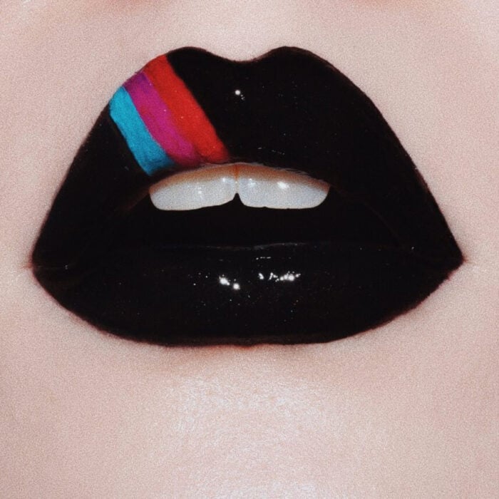 Künstlerisches Lippen Make-up von Maskenbildnerin Tatiana Rose;  Mund mit schwarzem Lippenstift und Glanz, bemalt mit blauen, rosa und roten Linien