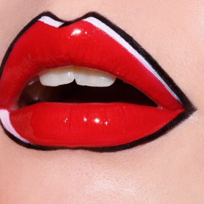 Maquillaje artístico de labios por maquilladora Tatiana Rose; boca con labial rojo con efecto de cómic con contorno negro y blanco, gloss