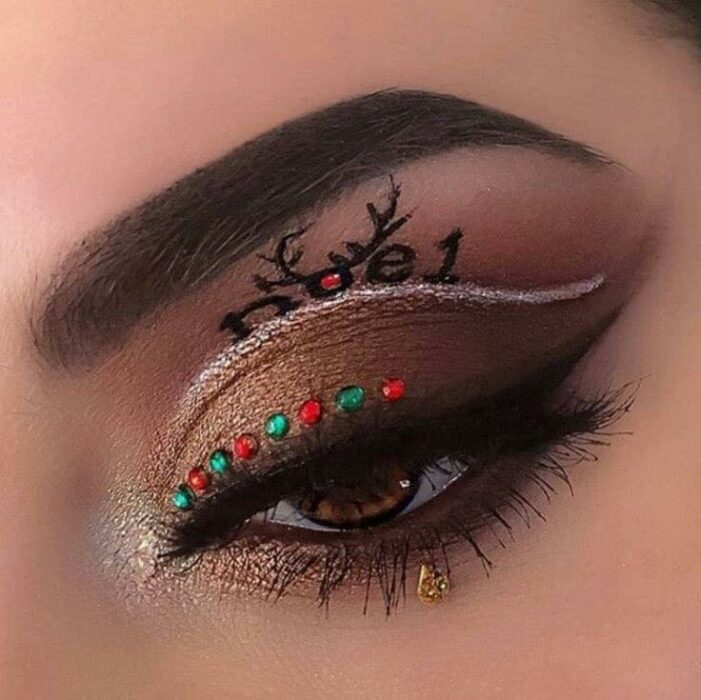 Chica con maquillaje de ojos en color café, delineado blanco y detalles en rojo;Maquillajes lindos para celebrar Navidad