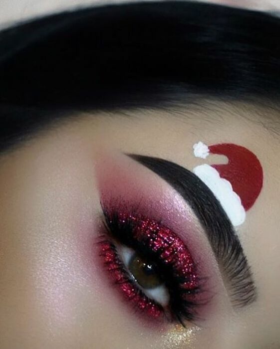 Chica con maquillaje para ojos en color rojo, con glitter; Maquillajes lindos para celebrar Navidad