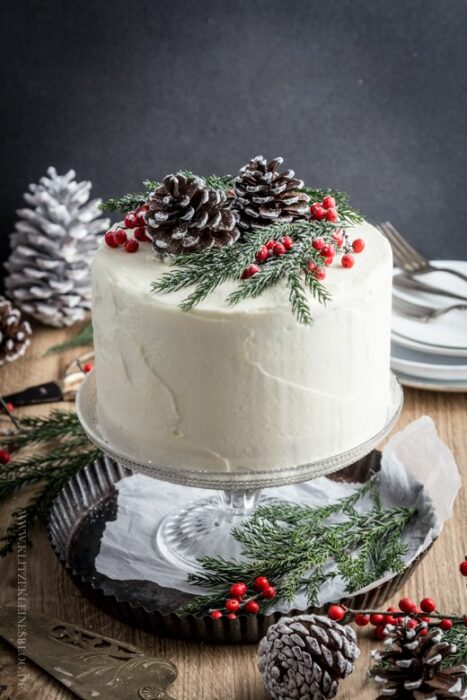 Pastel de Navidad de vainilla con decorado de piñas de pino y cerezas