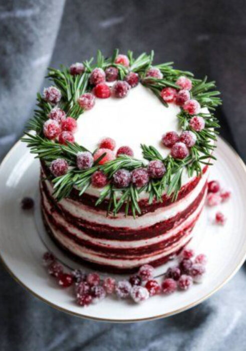 Pastel de Navidad de red velvet con relleno de vainilla y decorado de frutos rojos