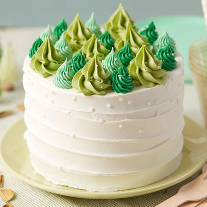 Pastel de Navidad de vainilla con decorado de pinos de diferentes verdes