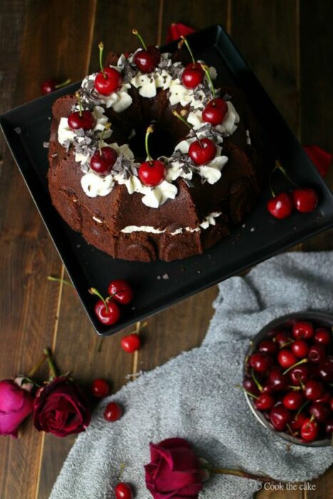 Pastel de Navidad de chocolate con relleno de crema batida con decorado de cerezas