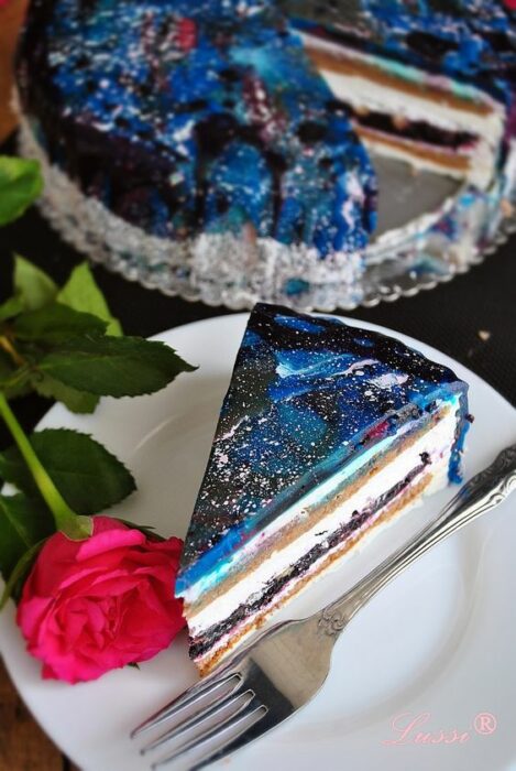 Rebanada de pastel rellena con queso crema y decorada con betún en tonos azules; Pasteles inspirados en la galaxia