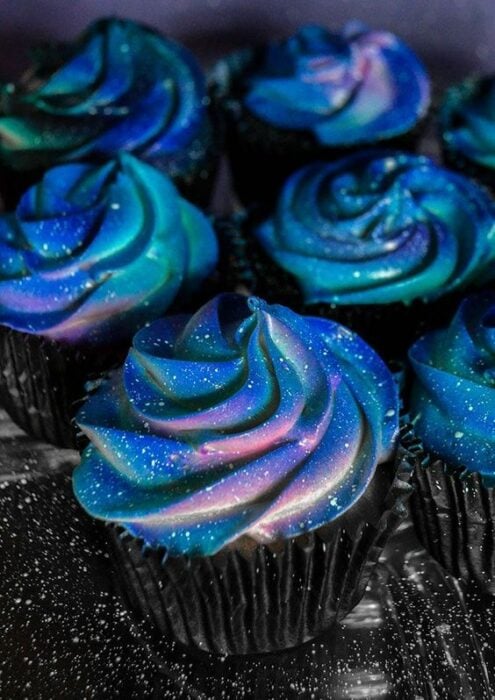 Cupcake decorado con betún de crema en tonos azules y morados; Pasteles inspirados en la galaxia