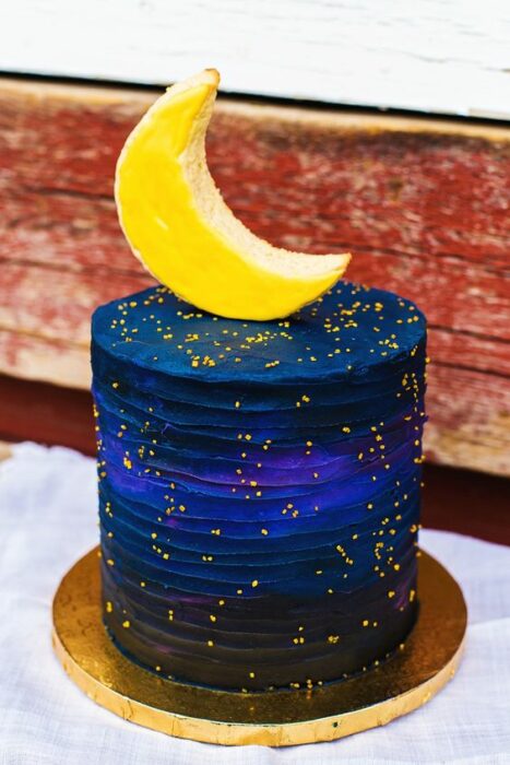 Pastel decorado con una media luna, con betún y chispas amarillas; Pasteles inspirados en la galaxia