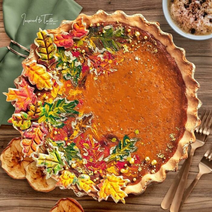 Pie de calabaza con decoración de hojas otoñales verdes, amarillas y naranjas