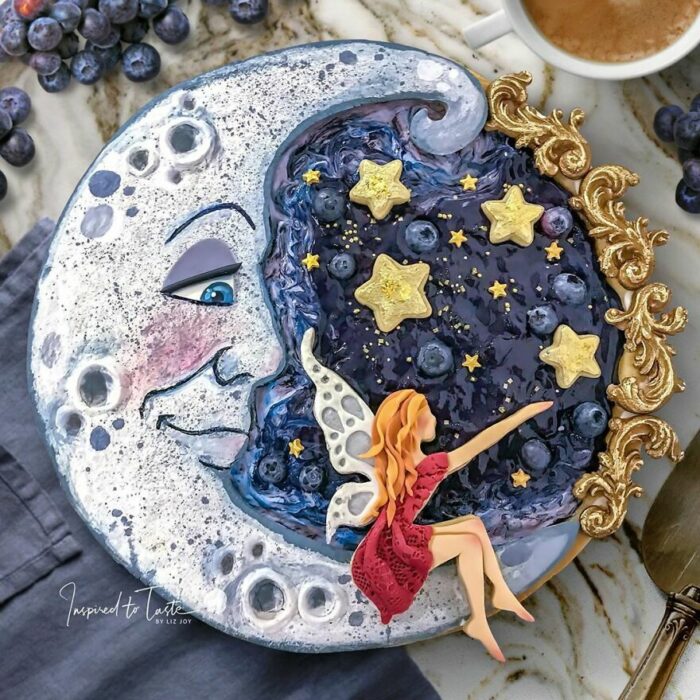 Pie de moras con cobertura en forma de luna con un hada sentada tocando las estrellas